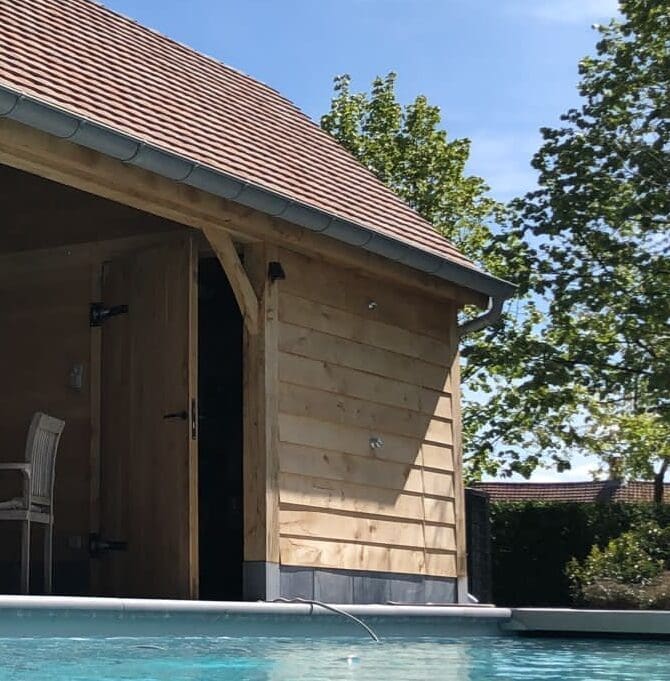 Oak poolhouse with tiled roof beside the swimming pool